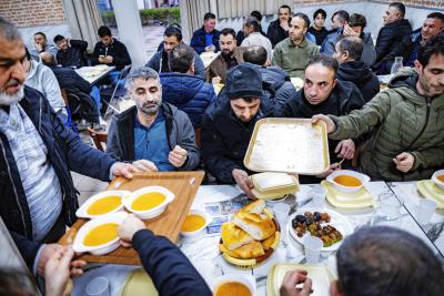 Bezoekers aan de Mevlana Moskee in Amsterdam tijdens een iftar. In een aantal moskeeën worden gratis maaltijden aangeboden. © Belga / ANP