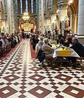 In de kerk waren de tafels versierd met gele paastinten. © Lieve Opdedrynck