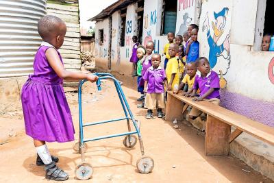 Hope vindt haar weg in en rond het schooltje in Kampala, in Uganda, dankzij een rollator. © Chelsea Bulteel