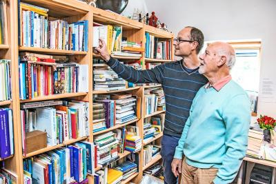 Mattias en Luk Bouckaert, zoon en echtgenoot van Rita Ghesquiere, bewonderen haar boekencollectie. © Luk Vanmaercke