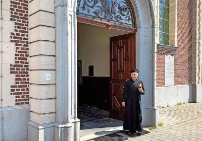 Luc Van Liedekerke leidt in de kerk in Strijtem bezoekers rond als pastoor Cuylits. © Jan De Bodt