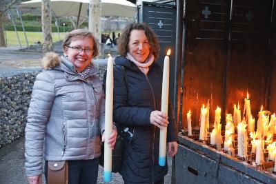 Ria Thaens (links) en Patricia Vuegen van LDB branden kaarsen voor het welslagen van de bedevaart. © LDB vzw