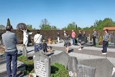 Familieleden staan op veilige afstand bij het afscheidsgebed op het kerkhof. © René Luyten
