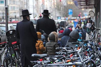 Chassidisch joodse mannen op weg met een klas kinderen. Antwerpen kent de grootste joodse-orthodoxe gemeenschap in ons land. © Jozefien Van Huffel