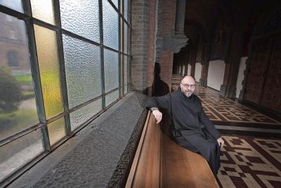 Pater Dirk Hanssens, hier in de pandgang van de abdij, houdt van de uitdrukking ‘bij jezelf wonen’. © Mine Dalemans
