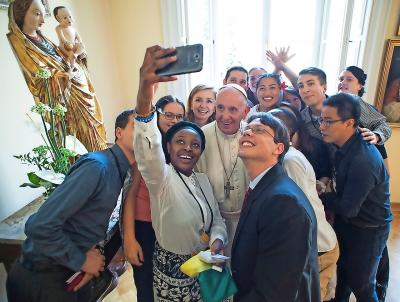 Onder het goedkeurende oog van de moeder van God en van de Kerk nemen jonge katholieken ongeremd een selfie met paus Franciscus. © KNA-Bild
