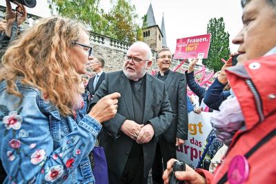 Kardinaal Reinhard Marx wordt in Fulda geconfronteerd met betogende vrouwen. © KNA-Bild