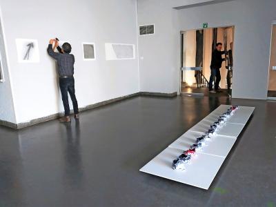 Vrijwilligers installeren met zorg en overleg de kunstwerken in het weldra te slopen cultuurcentrum in Zolder. © ART.27