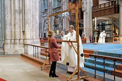 Uitreiking van de communie in de Dom van Keulen, voortaan achter plexiglas. © KNA-Bild
