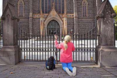 Een vrouw bidt tijdens de lockdown aan Saint Patrick’s Cathedral in Melbourne. © Belga Image