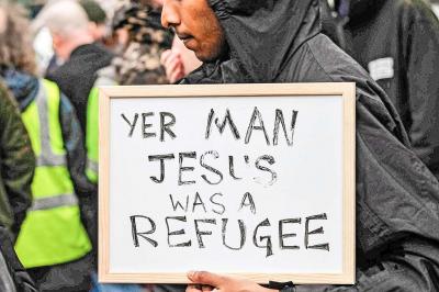 Een vluchteling in Belfast in Noord-Ierland wijst erop dat ook Jezus zelf ooit een vluchteling is geweest. © Image Select