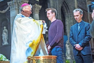 Dennis Lenders tijdens zijn doopplechtigheid in 2015, met de toenmalige bisschop van Gent Luc Van Looy. © Frank Bahnmüller